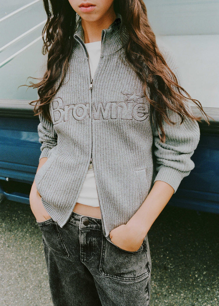 Chaqueta de punto gris oscuro con cremallera y logotipo bordado lucida sobre modelo