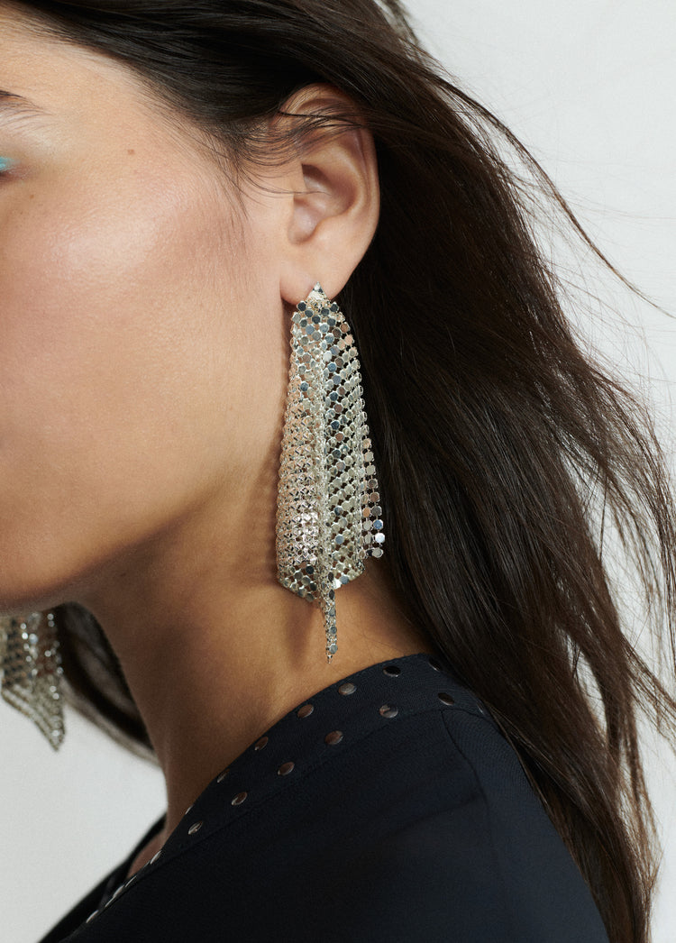Pendientes de malla metálica en forma de rombo de color plata lucidos sobre modelo