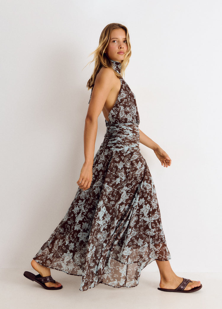 Vestido largo de cuello halter con estampado floral en marrón visto de perfil sobre modelo