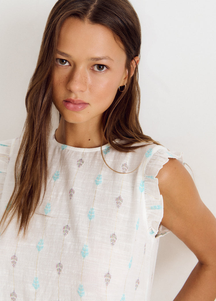 Blusa multiposición de color blanco con bordado floral y detalles en los hombros