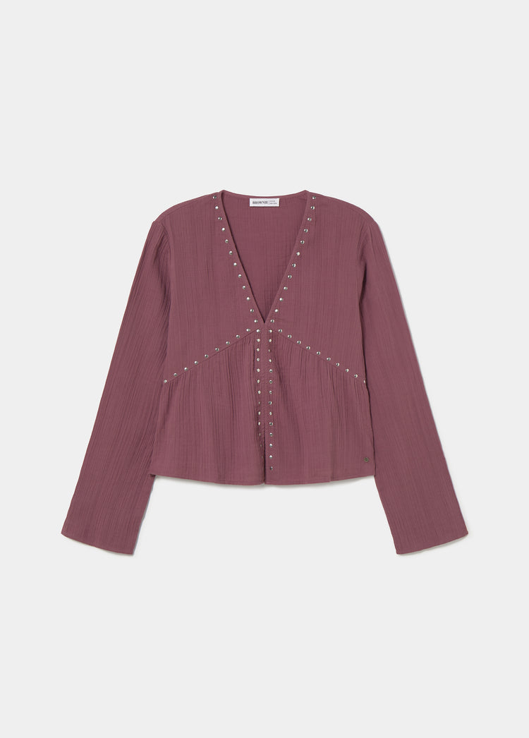 Blusa de manga larga en tono rosado con detalles de tachas en el escote y el bajo