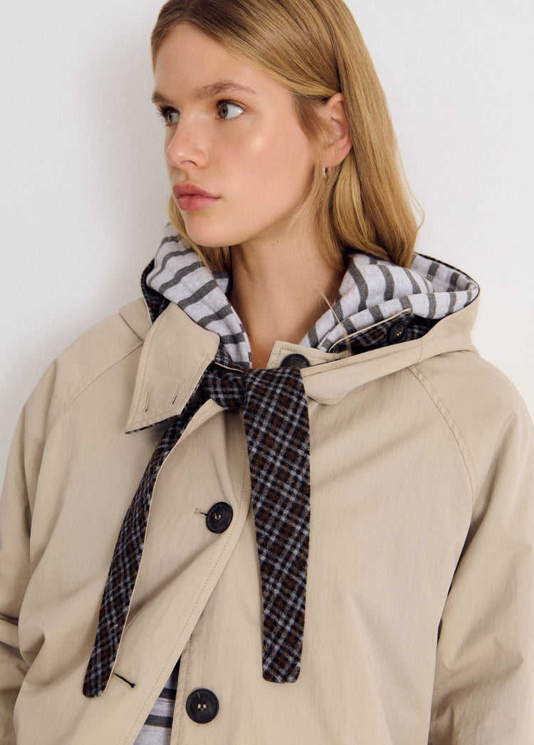 Chaqueta de gabardina beige con capucha y cierre de botones vista en detalle
