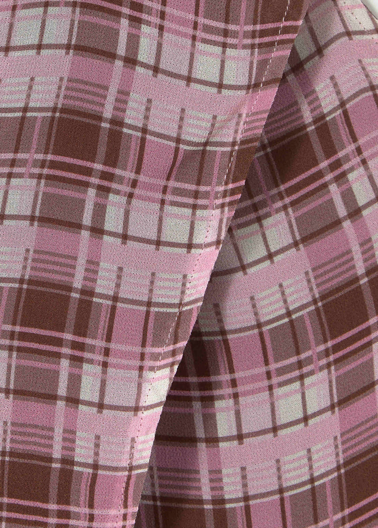Top halter de cuello drapeado en rosa con estampado a cuadros de líneas marrones y blancas en primer plano