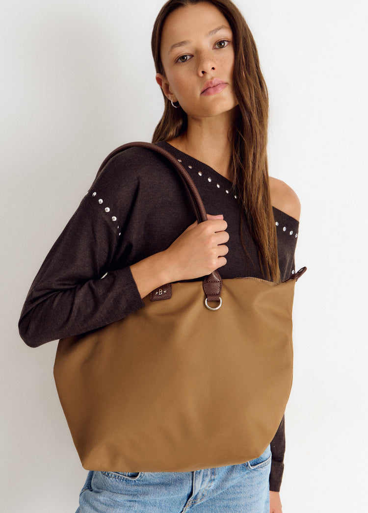 Bolso shopper camel de gran tamaño luciendo su asa de cuero y detalle metálico
