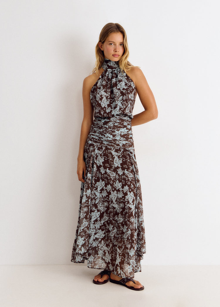 Vestido largo de tirantes halter con estampado floral en marrón sobre modelo