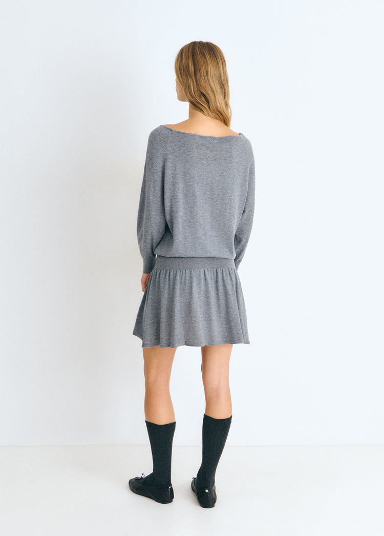 Vestido de punto gris con cuello abierto y falda fruncida, visto por detrás