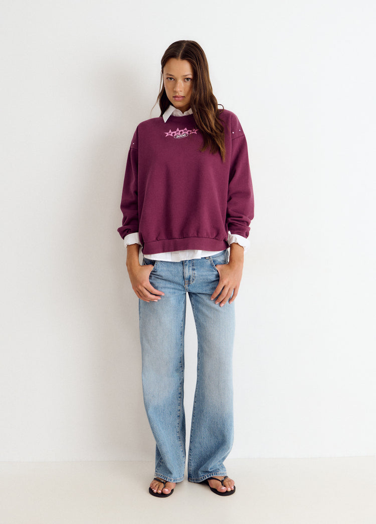 Sudadera de color granate con estampado de estrellas y tachas vista de frente