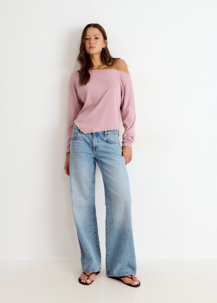 Camiseta de pico en rosa claro luciendo su detalle de tachas