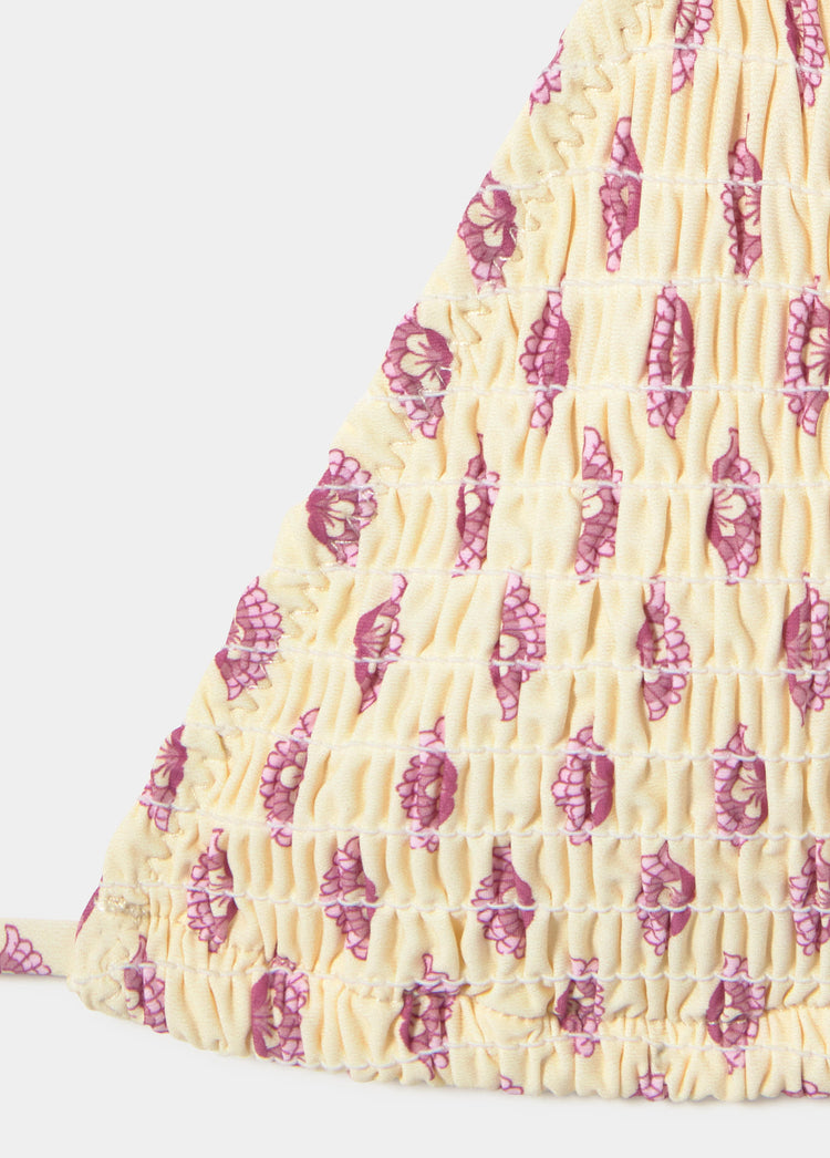 Top triangular smock de color amarillo con estampado floral en tonos rosados