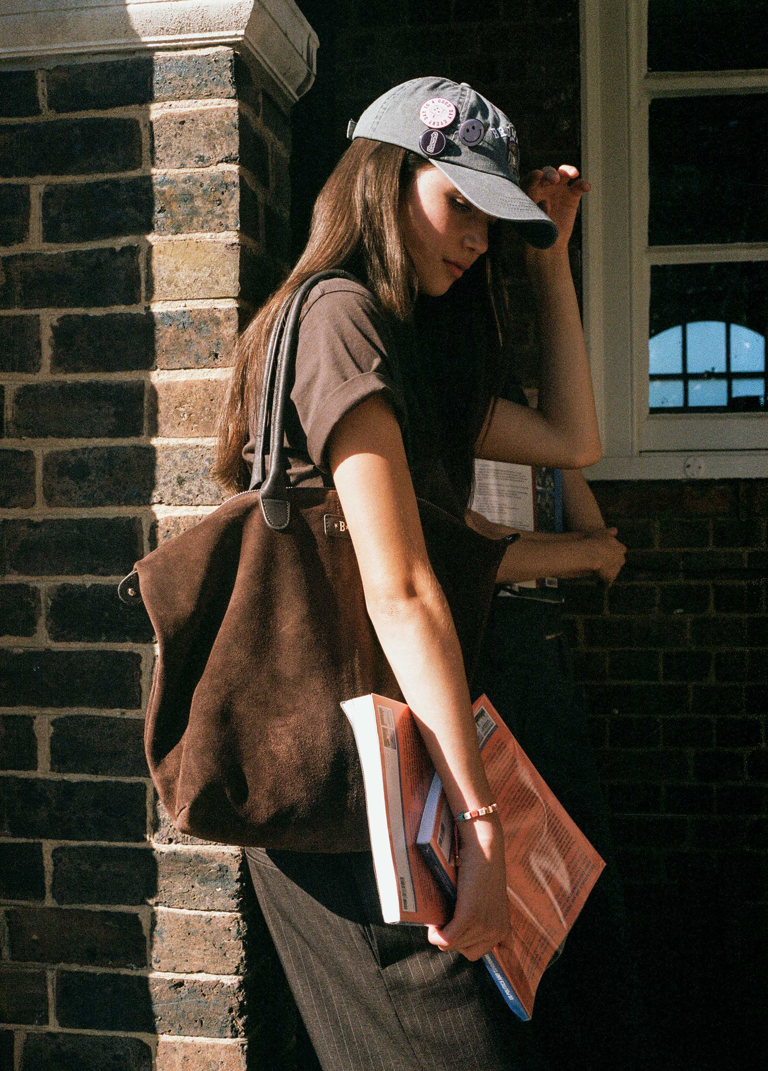 Bolso shopper de serraje color chocolate luciendo su perfil lateral con asas sobre el hombro