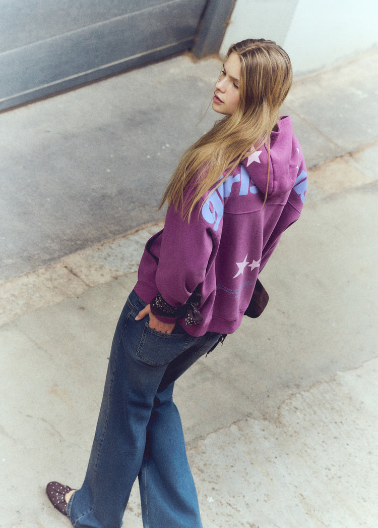 Sudadera de color granate con capucha y estampado de estrellas vista desde la espalda sobre modelo