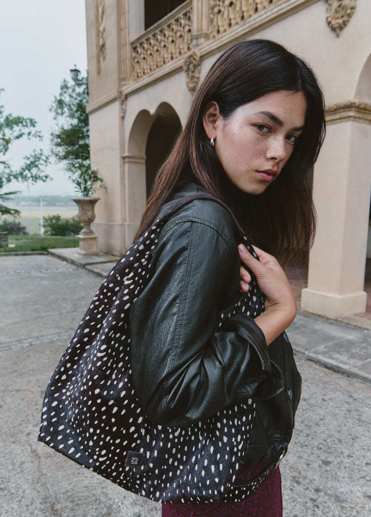 Bolso de hombro marrón con estampado animal print lucido sobre el hombro