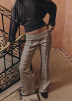 Pantalón de talle alto en color arena con cordones decorativos en el frontal de cada pierna