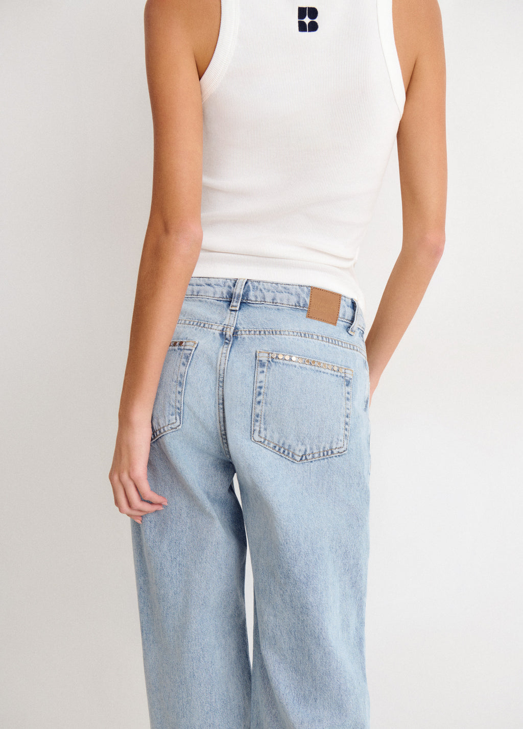 Jeans relaxed tachuelas y bajo desdoblado