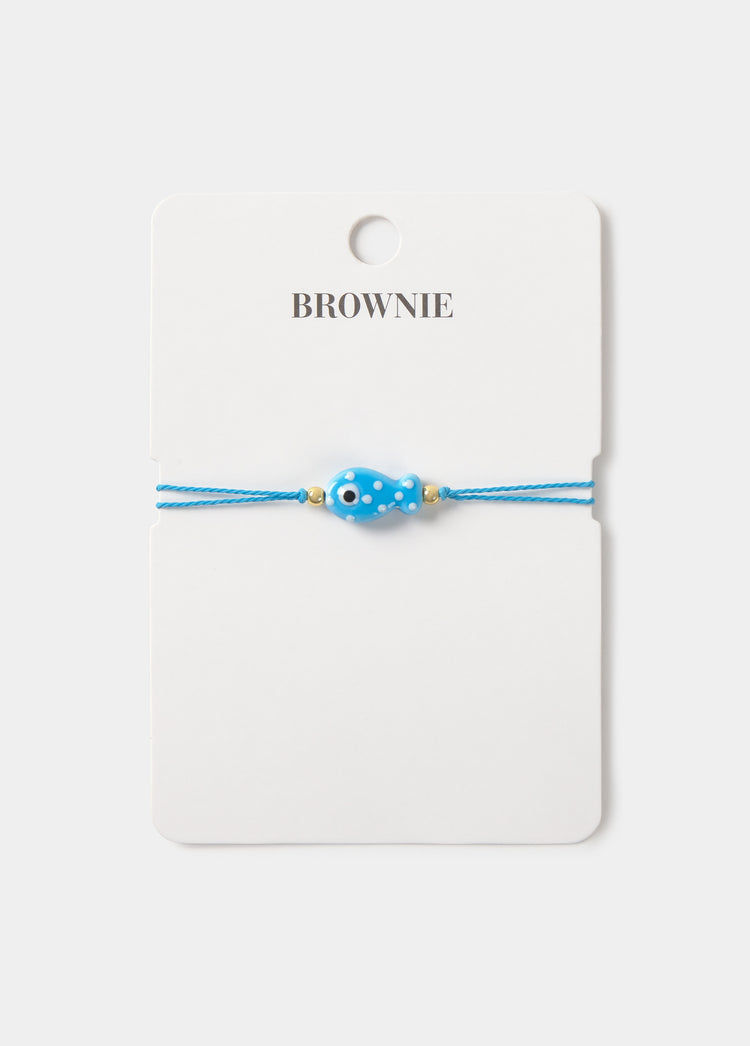 Pulsera de hilo azul con colgante de pez y detalles dorados sobre tarjeta de la marca