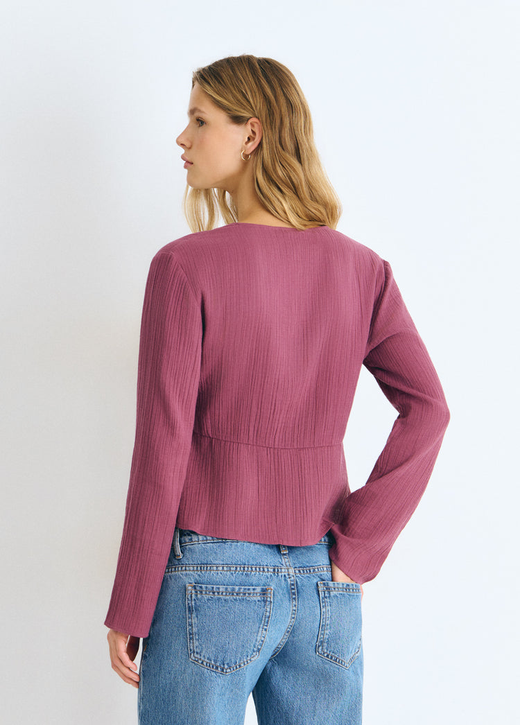 Blusa de manga larga en tono rosado vista por detrás