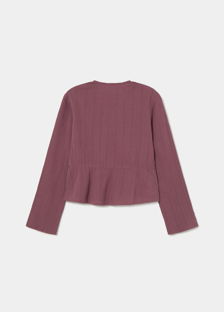 Blusa de manga larga en tono rosado vista por detrás con detalle de volante en la parte inferior