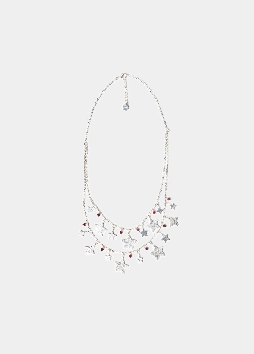 Collar doble de plata con colgantes de estrellas lucido sobre el escote drapeado