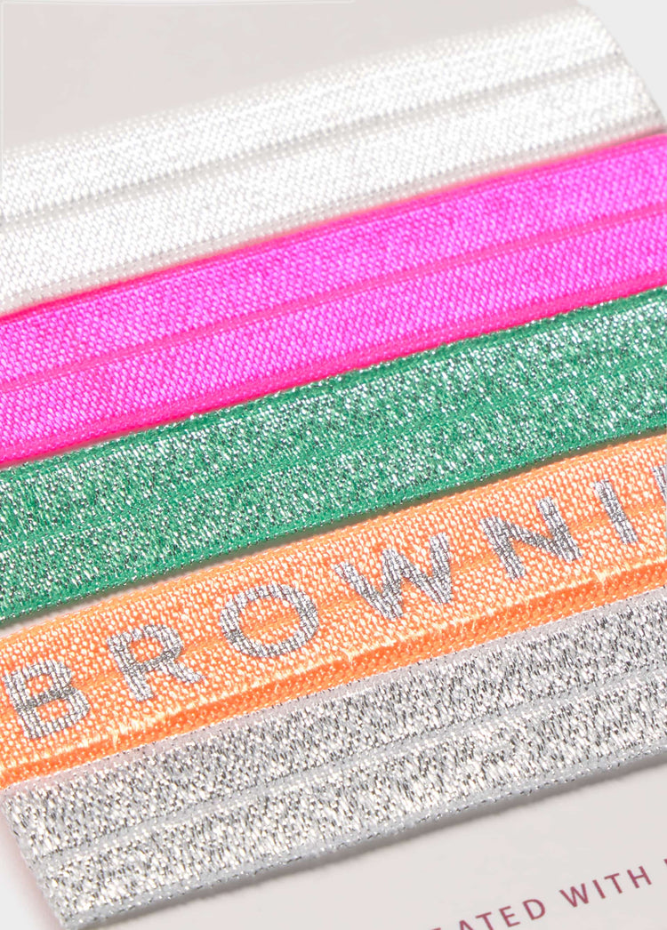 Gomas de pelo multicolor con brillo y la palabra brownie en relieve sobre fondo liso