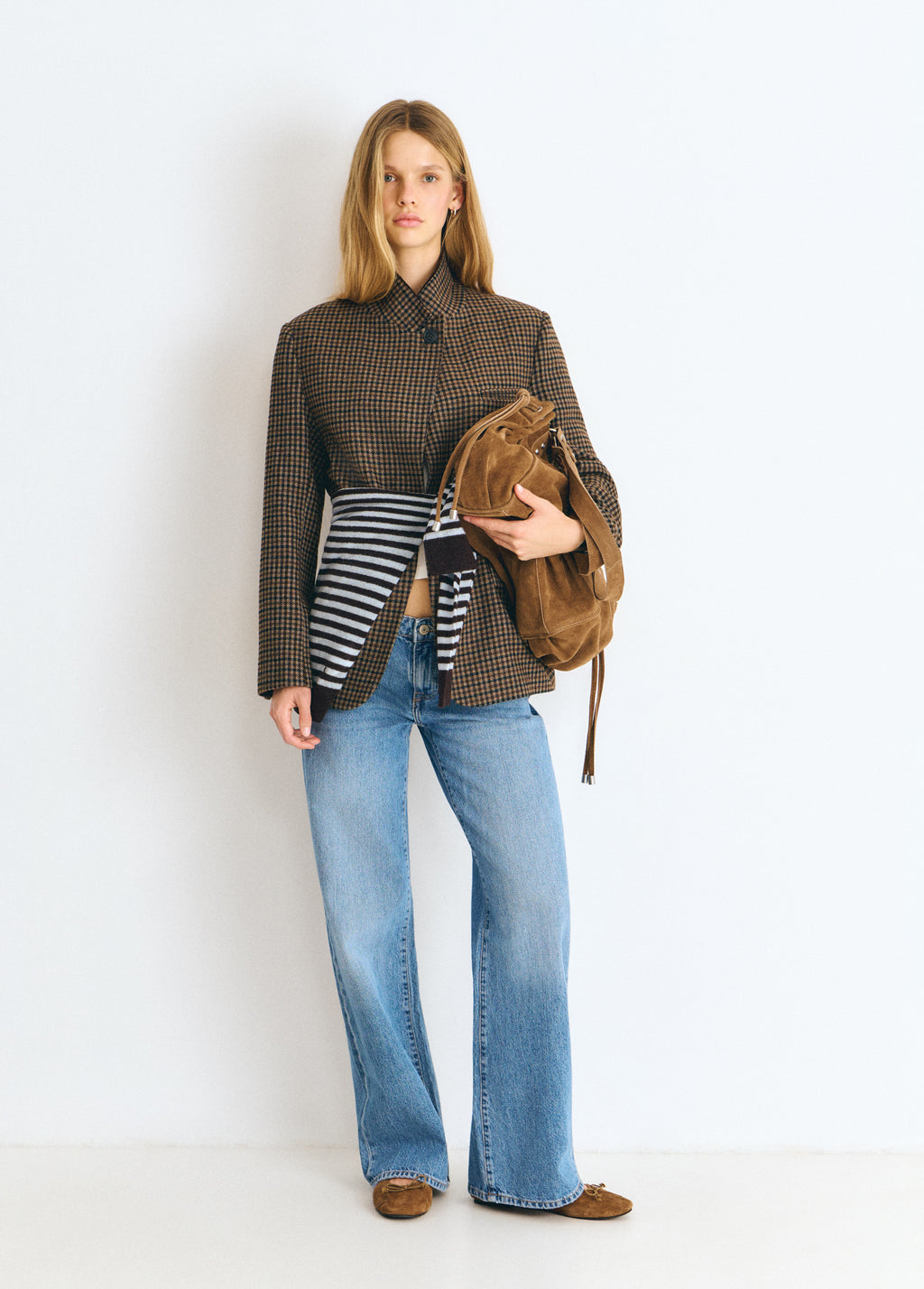 Bolso shopper fruncido de color camel lucido sobre modelo con su correa colgando