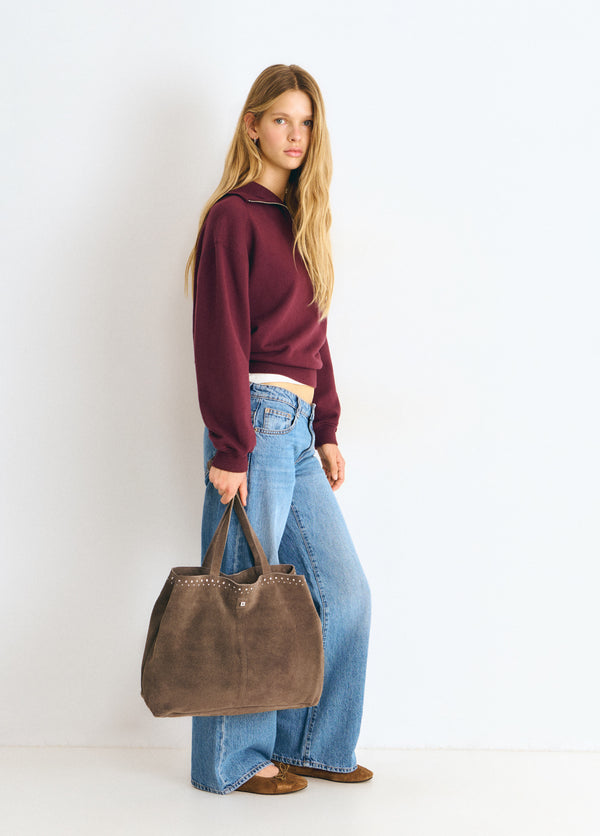 Bolso shopper de color topo con tachas lucido sobre modelo