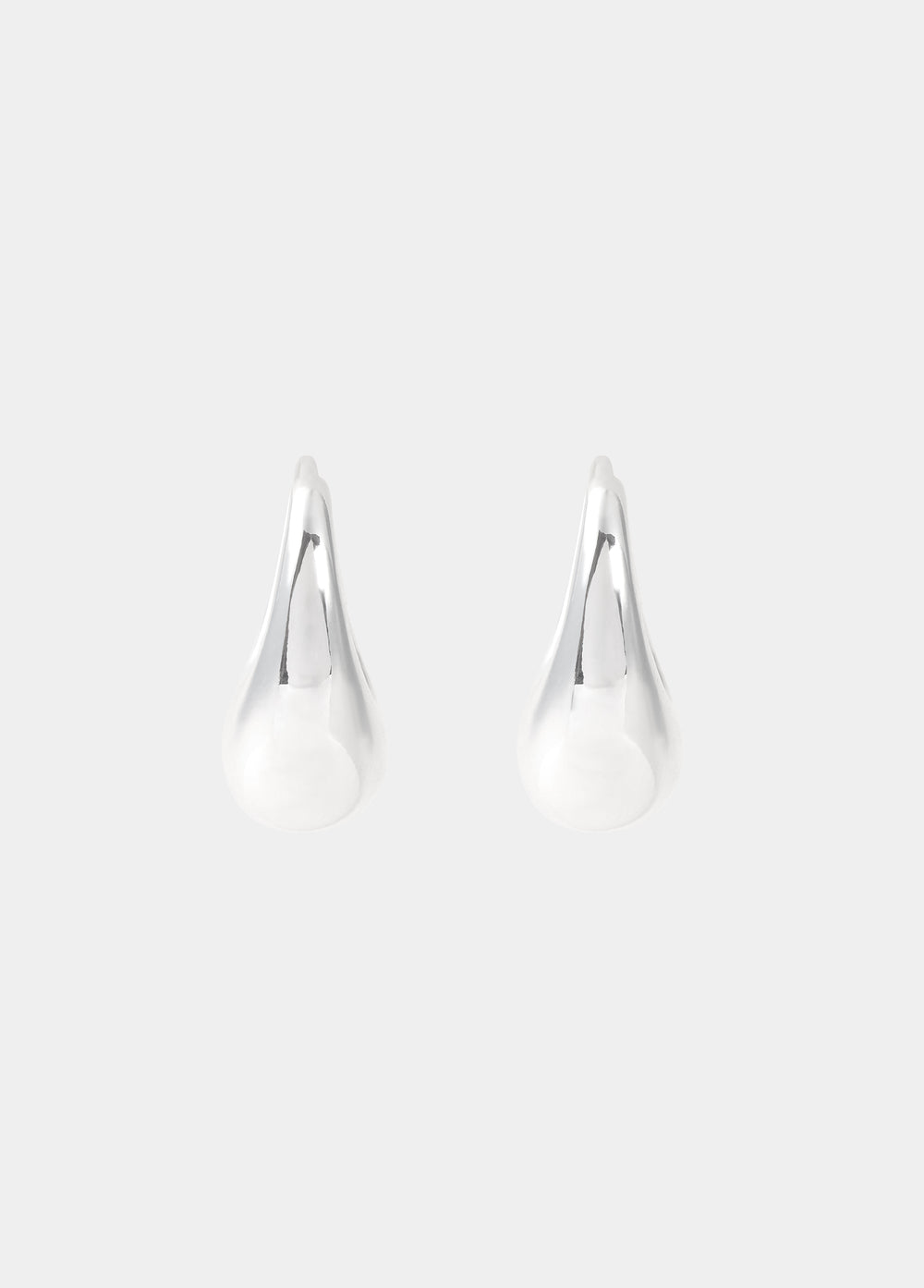 Aros pequeños de plata lucidos en el lóbulo de la oreja con un perfil elegante y minimalista