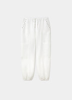 Pantalón bombacho de lino en blanco con detalle de tachas en los bolsillos