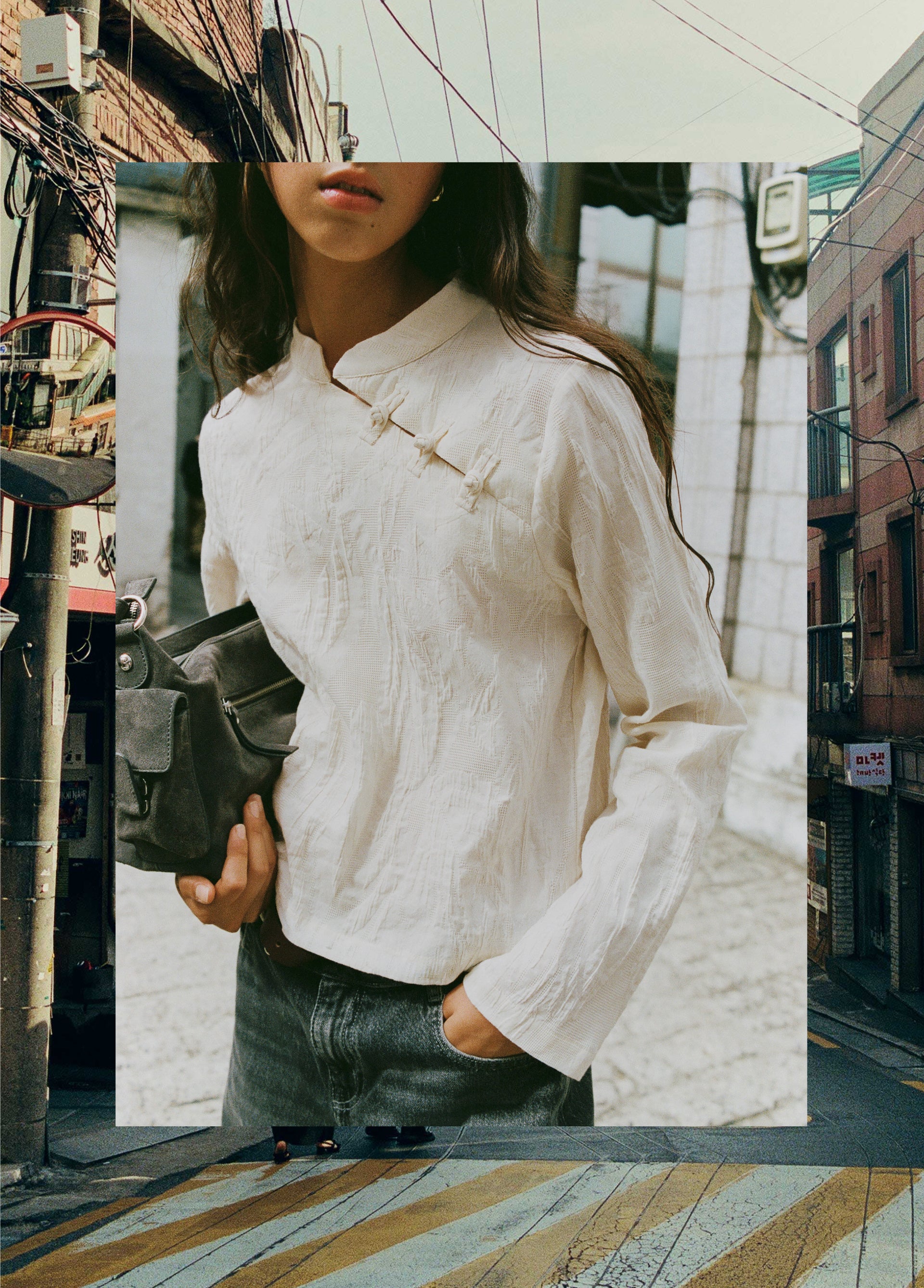 Blusa de manga larga en color crudo con cuello alto y detalle de botones en el pecho