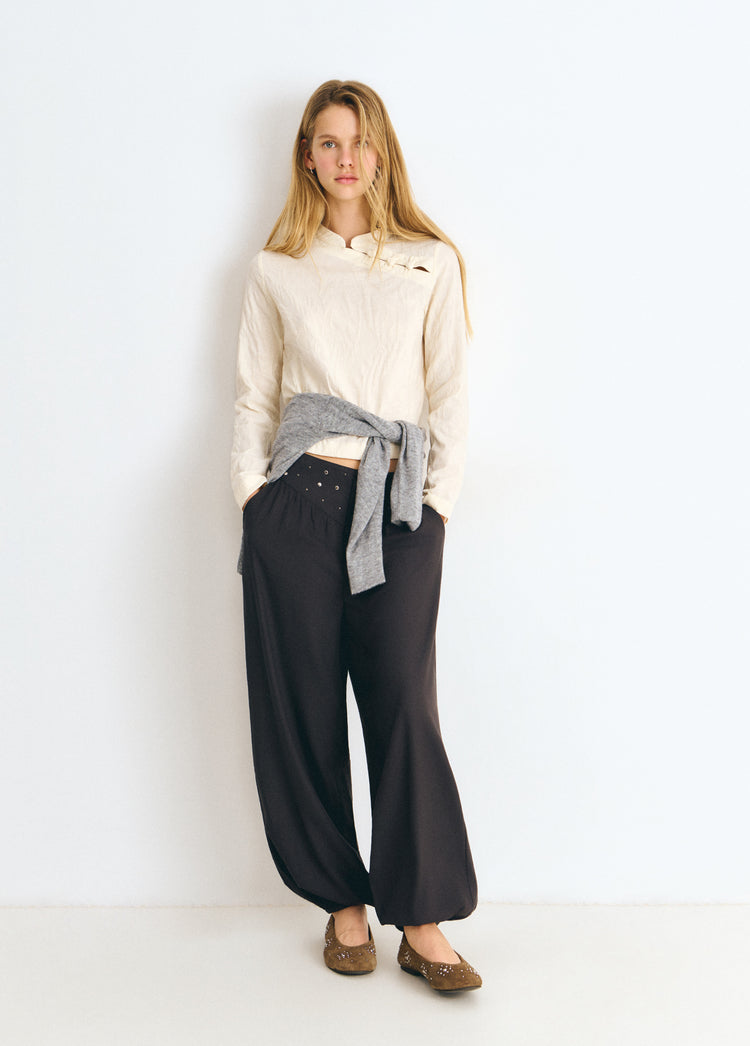 Blusa de tejido jacquard en color crudo con cuello alto y detalle de botones en el pecho