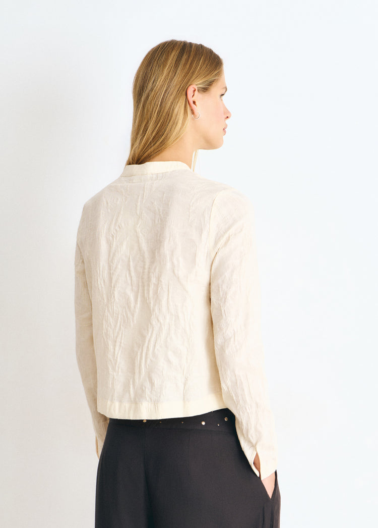 Blusa de tejido jacquard en color crudo vista por detrás con detalle de botones en la cintura